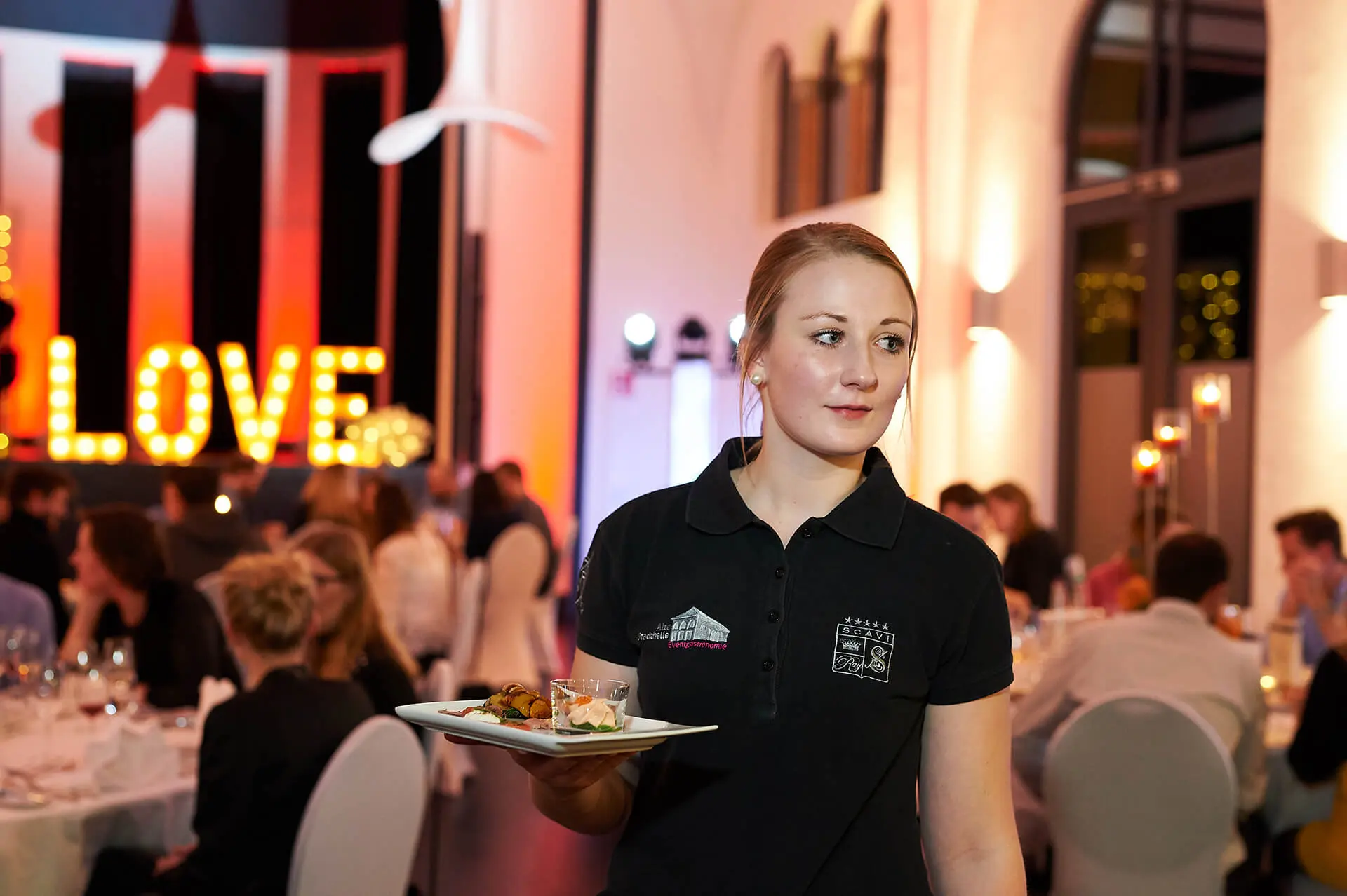 Servicekraft umgeben von zufriedenen Gästen