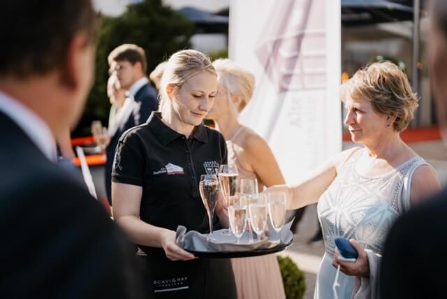 Servicekraft serviert Prosecco und Champagner für die Gäste vor der Location