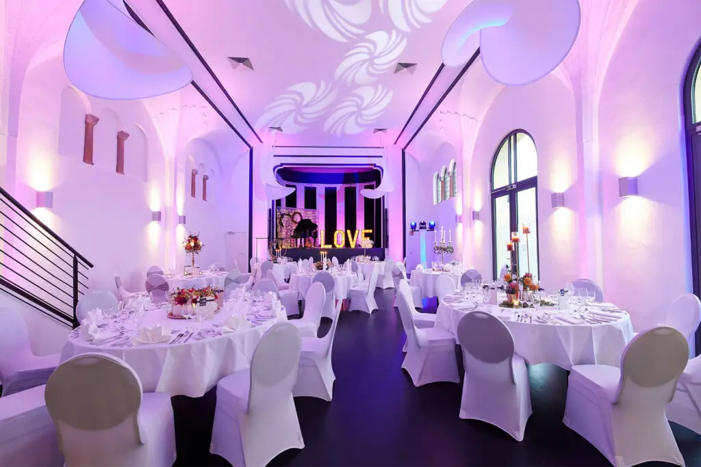 Toll beleuchteter Hauptraum der Alten Stadthalle mit Lichtformen an der Decke.